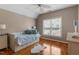 Sun-lit bedroom with hardwood floors, a white trundle bed and a ceiling fan, offering a cozy retreat at 803 Landuff Ct, Cary, NC 27519