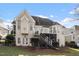 View of the back of a home with a back porch, backyard and a stairway to the 2nd level at 803 Landuff Ct, Cary, NC 27519
