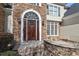 Beautiful front entrance with a stone archway, complemented by stone accents and professionally landscaped yard at 803 Landuff Ct, Cary, NC 27519