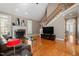 Living room featuring hardwood floors, fireplace, and adjacent staircase at 803 Landuff Ct, Cary, NC 27519