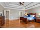 Relaxing main bedroom with tray ceiling, hardwood floors, and doorway to on-suite bath at 803 Landuff Ct, Cary, NC 27519