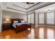 Spacious main bedroom with tray ceiling, hardwood floors, and plenty of natural light from large windows at 803 Landuff Ct, Cary, NC 27519