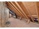 View of unfinished attic space showing wooden support beams and insulation at 100 Watkins Farm Rd, Rolesville, NC 27571