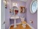 Elegant powder room with a pedestal sink, decorative mirror, and stylish lighting at 100 Watkins Farm Rd, Rolesville, NC 27571