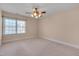 Spacious carpeted bedroom with a ceiling fan and large window bringing in plenty of natural light at 100 Watkins Farm Rd, Rolesville, NC 27571