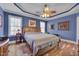 Serene bedroom featuring a large bed, hardwood floors, and natural light from the windows at 100 Watkins Farm Rd, Rolesville, NC 27571