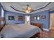 This main bedroom features light blue walls, a ceiling fan, and is attached to the main bath and closet at 100 Watkins Farm Rd, Rolesville, NC 27571