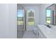 Bright bathroom featuring a walk-in shower, modern vanity, and a window with view to the outdoors at 105 Sherwood Ln, Hillsborough, NC 27278