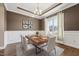 Dining room featuring hardwood floors, a modern chandelier, wainscoting, and a large window with natural light at 109 Hammermill Dr, Fuquay Varina, NC 27526