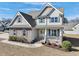 Charming two-story home featuring stone accents, gray siding, manicured landscaping, and a welcoming yellow front door at 109 Hammermill Dr, Fuquay Varina, NC 27526