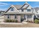 Charming two-story home featuring stone accents, gray siding, manicured landscaping, and a welcoming yellow front door at 109 Hammermill Dr, Fuquay Varina, NC 27526