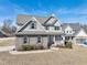 Beautiful two-story home with stone accents, gray siding, manicured landscaping, and a welcoming front porch at 109 Hammermill Dr, Fuquay Varina, NC 27526