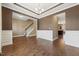 Living room featuring hardwood floors, crown molding, and wainscoting near a staircase and arched entryway at 109 Hammermill Dr, Fuquay Varina, NC 27526