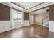 Elegant living room with hardwood floors, crown molding, wainscoting, a large window and modern chandelier at 109 Hammermill Dr, Fuquay Varina, NC 27526