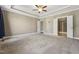 Large main bedroom featuring neutral walls, carpet, and ensuite bathroom and closet entrances at 109 Hammermill Dr, Fuquay Varina, NC 27526