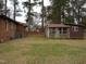 Exterior view of back yard with brick home and storage outbuilding in the distance at 110 N 8Th St, Erwin, NC 28339