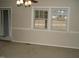 Living room with neutral colored walls, carpet, a ceiling fan, and windows at 110 N 8Th St, Erwin, NC 28339