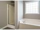 Bathroom showcasing a tub and a shower with glass door, complemented by neutral color tones at 1113 Crendall Way, Wake Forest, NC 27587