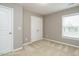 A tidy bedroom with beige carpet, white trim, a double door closet and a window at 1113 Crendall Way, Wake Forest, NC 27587