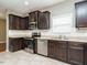 Modern kitchen with dark wood cabinets and stainless steel appliances at 1113 Crendall Way, Wake Forest, NC 27587