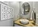 Stylish half-bath with modern round mirror, decorative elements, and beautiful sink design at 1154 Smith Creek Way, Wake Forest, NC 27587