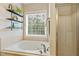 Bright bathroom features a large soaking tub, tile surround and a shower with glass door at 1154 Smith Creek Way, Wake Forest, NC 27587
