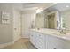 Bright bathroom with double vanity, framed mirror, tile floor and plenty of storage in white cabinets at 1154 Smith Creek Way, Wake Forest, NC 27587