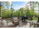 Outdoor deck featuring comfortable seating, a grill, and a wooded landscape view at 1154 Smith Creek Way, Wake Forest, NC 27587