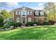 Stately two-story brick home featuring a manicured lawn and mature landscaping at 1154 Smith Creek Way, Wake Forest, NC 27587