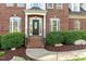 Inviting front entrance with a black front door, sidelights, and manicured shrubs at 1154 Smith Creek Way, Wake Forest, NC 27587