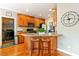 Kitchen features hardwood floors, wooden cabinetry, stainless appliances, and breakfast bar seating at 1154 Smith Creek Way, Wake Forest, NC 27587