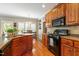 Charming kitchen with hardwood floors, wooden cabinetry, and open view to breakfast nook at 1154 Smith Creek Way, Wake Forest, NC 27587