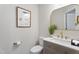 Close-up of the half bathroom featuring modern vanity with gold fixtures and neutral decor at 1309 N Holland Rd, Fuquay Varina, NC 27526
