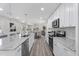 Bright kitchen boasts granite counters, modern appliances, white cabinets, and wood flooring at 1309 N Holland Rd, Fuquay Varina, NC 27526