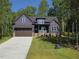 Charming two-story home with a beautiful dark-blue exterior, covered porch, and an attached two-car garage at 140 Pilot Ridge Rd, Zebulon, NC 27597