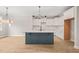 Modern kitchen featuring white cabinets, a center island with a sink, and stylish lighting fixtures at 140 Pilot Ridge Rd, Zebulon, NC 27597