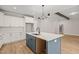 Modern kitchen with white cabinets, an island sink, and stainless appliances, open to the living room at 140 Pilot Ridge Rd, Zebulon, NC 27597