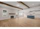 Open-concept living room features wood floors, fireplace, exposed beams and modern kitchen with island at 140 Pilot Ridge Rd, Zebulon, NC 27597