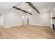 Bright, open living room with exposed beams, wood-look floors, a fireplace, and access to the upper floors at 140 Pilot Ridge Rd, Zebulon, NC 27597