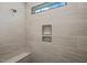 Tiled shower featuring a bench, rainfall shower head, and built-in shelving at 140 Pilot Ridge Rd, Zebulon, NC 27597