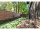 Landscaped backyard featuring a wooden deck, privacy fence, turf, and mature shade trees at 1406 Lyon St # 101, Raleigh, NC 27608