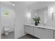 Bathroom boasts double vanity, quartz counters, and a toilet room with a large window at 1406 Lyon St # 101, Raleigh, NC 27608