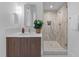 Modern bathroom featuring a sleek vanity with a wood cabinet and a glass-enclosed shower with neutral tile at 1406 Lyon St # 101, Raleigh, NC 27608