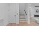 Hallway with hardwood floors, a modern staircase, a side entry door, and a glimpse of the living room at 1406 Lyon St # 101, Raleigh, NC 27608