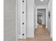 Hallway with hardwood floors and white walls leading to a bright living space at 1406 Lyon St # 101, Raleigh, NC 27608