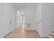Hallway featuring light wood floors, white walls and doors, and ample natural light at 1406 Lyon St # 101, Raleigh, NC 27608