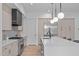 Modern kitchen with stainless steel appliances, a spacious island, and elegant lighting at 1406 Lyon St # 101, Raleigh, NC 27608