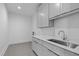 Modern laundry room with tile flooring, sink, chrome faucet, and bright cabinets at 1406 Lyon St # 101, Raleigh, NC 27608