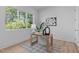 Bright office space with a wooden desk, patterned rug, and natural light from a large window at 1406 Lyon St # 101, Raleigh, NC 27608