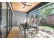 Relaxing screened in porch featuring a wooden ceiling, gray siding, and an outdoor dining set at 1406 Lyon St # 101, Raleigh, NC 27608